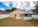 Backyard view with beige house, enclosed patio, and white fence at 10934 Rushwood Way, Clermont, FL 34714