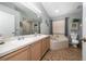 Bathroom features a double sink vanity, tub with shower and beige tile flooring at 10934 Rushwood Way, Clermont, FL 34714