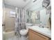 Bathroom featuring a shower-tub combo with decorative shower curtain and a vanity at 10934 Rushwood Way, Clermont, FL 34714