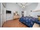 Cozy bedroom with vaulted ceilings, wood floors, ceiling fan and blue floral bedding at 10934 Rushwood Way, Clermont, FL 34714