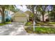 Inviting one story home featuring manicured lawn, mature trees, and charming curb appeal at 10934 Rushwood Way, Clermont, FL 34714