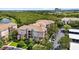 Scenic aerial view of the condominium complex featuring landscaping, parking, and nearby golf course at 1351 Venezia Ct # 201, Davenport, FL 33896
