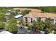 Serene aerial view of the condominium complex displaying the building layout, trees and parking at 1351 Venezia Ct # 201, Davenport, FL 33896