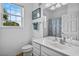 Bright bathroom with a window for natural light, a large mirror, and a shower with a colorful curtain at 1351 Venezia Ct # 201, Davenport, FL 33896