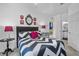 Comfortable bedroom features a chevron comforter, stylish decor, and an ensuite bathroom for ultimate convenience at 1351 Venezia Ct # 201, Davenport, FL 33896