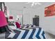This bedroom showcases a chevron patterned comforter, white walls, and an ensuite bathroom for added convenience at 1351 Venezia Ct # 201, Davenport, FL 33896