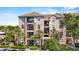 Beautiful condominium building featuring a tile roof, multiple balconies, and tropical landscaping at 1351 Venezia Ct # 201, Davenport, FL 33896