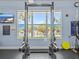 Bright fitness center featuring squat racks and a window view of the pool and palm trees at 1351 Venezia Ct # 201, Davenport, FL 33896