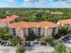 Scenic aerial view of complex with terracotta roofs, lush landscaping, and ample parking at 1361 Tuscan Ter # 7303, Davenport, FL 33896