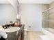 Bright bathroom featuring a shower with glass doors, a granite countertop, and neutral tiling at 1361 Tuscan Ter # 7303, Davenport, FL 33896