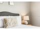 Close-up view of a comfortable bed with stylish pillows and a bedside lamp in a serene bedroom setting at 1361 Tuscan Ter # 7303, Davenport, FL 33896