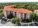 Aerial view of a multi-story condo building with a red tile roof and ample parking at 1361 Tuscan Ter # 7303, Davenport, FL 33896