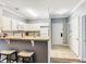 Open kitchen with breakfast bar, featuring white cabinets and modern appliances, adjacent to dining area at 1361 Tuscan Ter # 7303, Davenport, FL 33896