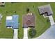 Aerial view of a well-maintained home featuring a driveway, a brown roof, and an expansive, well-manicured lawn at 1405 Hillsborough Way, Kissimmee, FL 34759