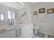 Bathroom features a long vanity with marble counters, white cabinets and a framed mirror at 1405 Hillsborough Way, Kissimmee, FL 34759