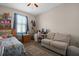 Bedroom featuring a twin bed, loveseat, desk and natural light at 1405 Hillsborough Way, Kissimmee, FL 34759
