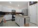 Bright kitchen featuring an island, white cabinets, stainless steel appliances, and tile floors at 1405 Hillsborough Way, Kissimmee, FL 34759