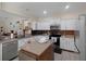 Spacious kitchen featuring an island, white cabinets, stainless steel appliances, and tile backsplash at 1405 Hillsborough Way, Kissimmee, FL 34759