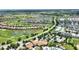 This aerial shot shows a Primary-planned community, a pond, and a large clubhouse at 1452 Mickelson Ct, Davenport, FL 33896