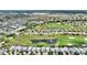 This photo captures an aerial view of a community surrounded by a golf course and a pond at 1452 Mickelson Ct, Davenport, FL 33896