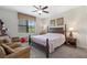 Comfortable bedroom with a four-poster bed, ceiling fan, and window overlooking the outdoors at 1452 Mickelson Ct, Davenport, FL 33896