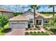 Charming single Gathering home featuring a beautiful tile roof, manicured landscaping, and a two-car garage at 1452 Mickelson Ct, Davenport, FL 33896