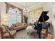 Elegant living room with a baby grand piano, decorative windows, and comfortable seating at 1452 Mickelson Ct, Davenport, FL 33896