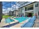 Backyard pool area with lounge chairs, a hot tub, and a screened-in enclosure at 1452 Mickelson Ct, Davenport, FL 33896