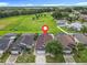 Aerial view of home's location with lush green field in background among a community of homes at 1515 Oak Hill Trl, Kissimmee, FL 34747