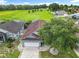 Aerial view of home with lush green field in background, mature landscaping and a large driveway at 1515 Oak Hill Trl, Kissimmee, FL 34747