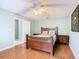 Bright bedroom with a wooden bed frame, ceiling fan, and en-suite bathroom at 1515 Oak Hill Trl, Kissimmee, FL 34747