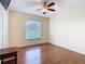 Bedroom features wood floors, a window with blinds, a ceiling fan and a double door closet at 1515 Oak Hill Trl, Kissimmee, FL 34747