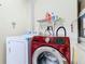 Laundry room featuring a red Samsung washing machine and a white dryer at 1515 Oak Hill Trl, Kissimmee, FL 34747