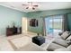 Spacious living room with tile floor, ceiling fan, and access to screened patio at 1515 Oak Hill Trl, Kissimmee, FL 34747