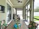 Covered patio with a tiled table and seating overlooking the yard with privacy fence at 15230 Evergreen Oak Loop, Winter Garden, FL 34787