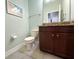 Cozy half bath with a granite-topped vanity, neutral color scheme, and modern fixtures at 15230 Evergreen Oak Loop, Winter Garden, FL 34787