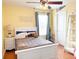 Charming bedroom featuring hardwood floors, ceiling fan, ample natural light, and stylish decor, offering a comfortable retreat at 15230 Evergreen Oak Loop, Winter Garden, FL 34787