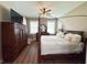 Primary bedroom features a four-poster bed, ceiling fan, wood dresser, and TV at 15230 Evergreen Oak Loop, Winter Garden, FL 34787