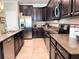Well-equipped kitchen featuring dark wood cabinets, stainless steel appliances, and granite countertops at 15230 Evergreen Oak Loop, Winter Garden, FL 34787