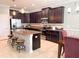 Modern kitchen boasting an island with seating, stainless appliances, and dark wood cabinetry at 15230 Evergreen Oak Loop, Winter Garden, FL 34787
