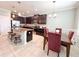 Inviting kitchen showcasing an island with bar stools, stainless appliances, and dark cabinetry at 15230 Evergreen Oak Loop, Winter Garden, FL 34787