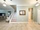 Open-concept living area with staircase, light tile flooring, and modern lighting fixtures offering a seamless flow at 15230 Evergreen Oak Loop, Winter Garden, FL 34787