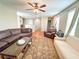 Comfortable living room with hardwood floors, ceiling fan, and ample seating at 15230 Evergreen Oak Loop, Winter Garden, FL 34787