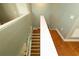Staircase with hardwood steps and white railings, leading to upper level at 15230 Evergreen Oak Loop, Winter Garden, FL 34787