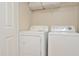 Efficient laundry area features a side-by-side washer and dryer, and shelving for storage at 193 Longview Ave # 203, Celebration, FL 34747