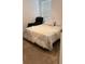 Cozy bedroom featuring neutral tones, a comfortable bed with decorative throw, and a relaxing black armchair at 1940 Egret Meadows Ave, Kissimmee, FL 34744