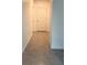 Inviting hallway with neutral tiled flooring and a white door, providing a clean and simple transition space at 1940 Egret Meadows Ave, Kissimmee, FL 34744