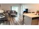 Open-concept living room with modern flooring, a comfortable sofa, and seamless flow into the kitchen area at 1940 Egret Meadows Ave, Kissimmee, FL 34744