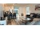 Open concept living space with modern finishes, including wood floors, a breakfast bar, and a comfortable seating area at 1940 Egret Meadows Ave, Kissimmee, FL 34744