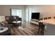 Comfortable living room featuring hardwood floors, a couch, and sliding door access to the outside at 1940 Egret Meadows Ave, Kissimmee, FL 34744